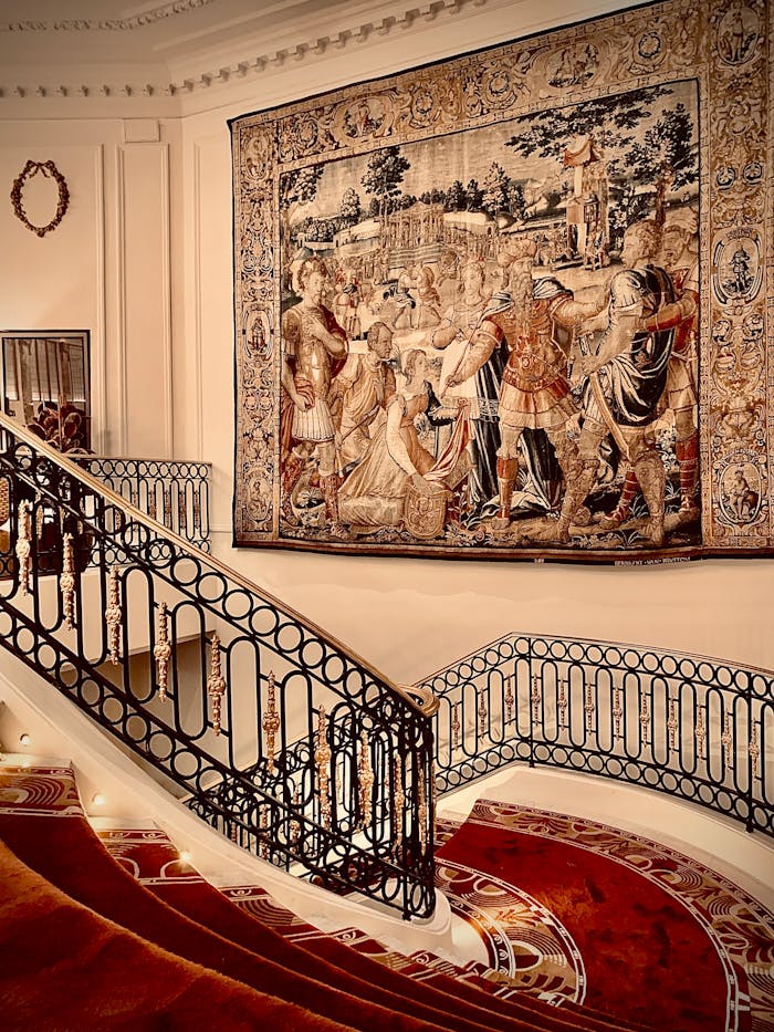 Ornate staircase featuring a historical tapestry in a luxurious Madrid setting.